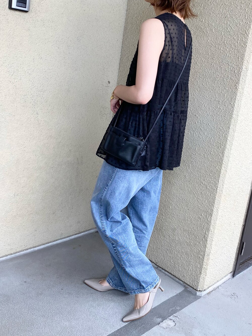 ブラック系のシャツ/ブラウス、ブルー系のデニムパンツ、グレー系のパンプスを着用したレディースの夏コーディネートの3枚目の写真