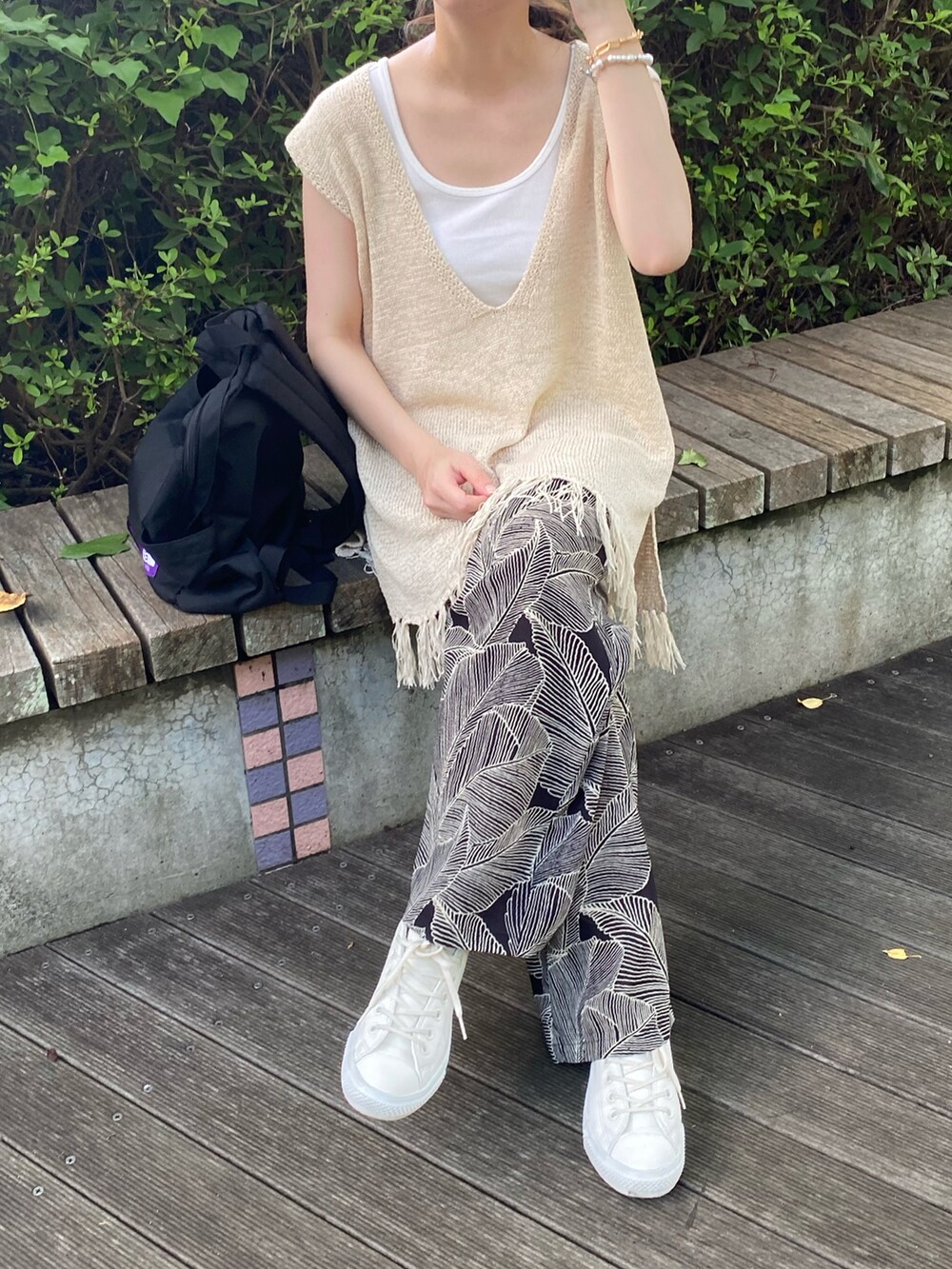 ベージュ系のベスト、ホワイト系のタンクトップ、ブラック系のその他パンツを着用したレディースの夏コーディネートの2枚目の写真