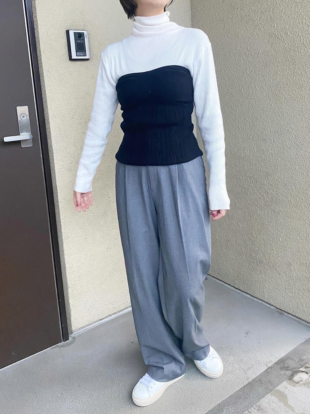 ホワイト系のニット/セーター、ブラック系のその他トップス、ベージュ系のパンツを着用したレディースの冬コーディネートの2枚目の写真