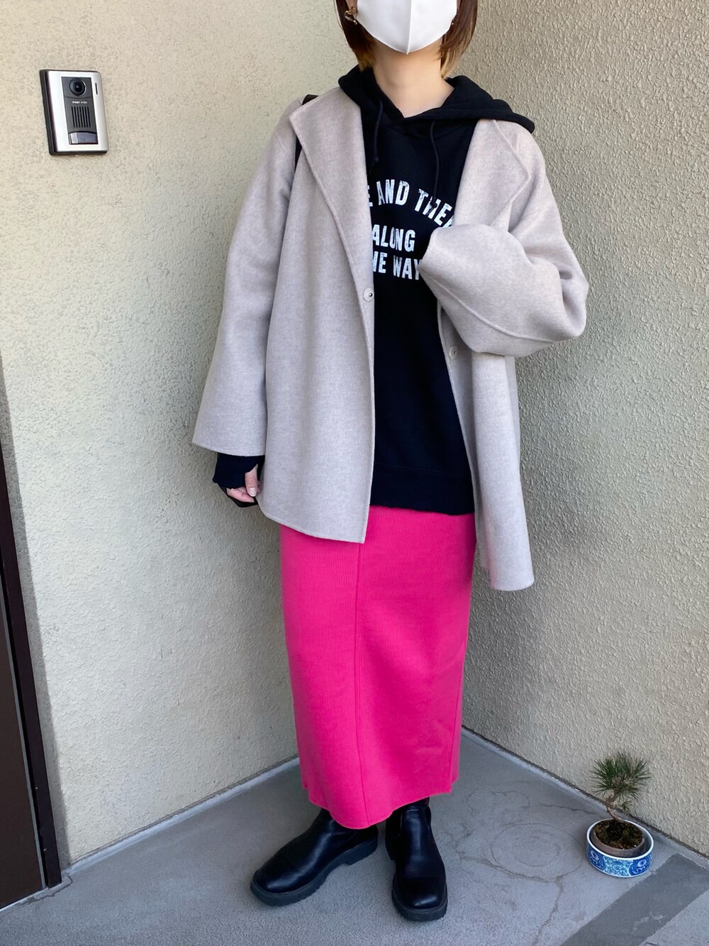 ブラック系のパーカー、ピンク系のスカートを着用したレディースの春コーディネートの4枚目の写真