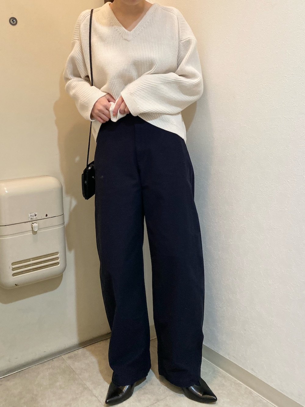 ブルー系のカーゴパンツ、ブラック系のパンプス、ホワイト系のニット/セーターを着用したレディースの冬コーディネートの2枚目の写真