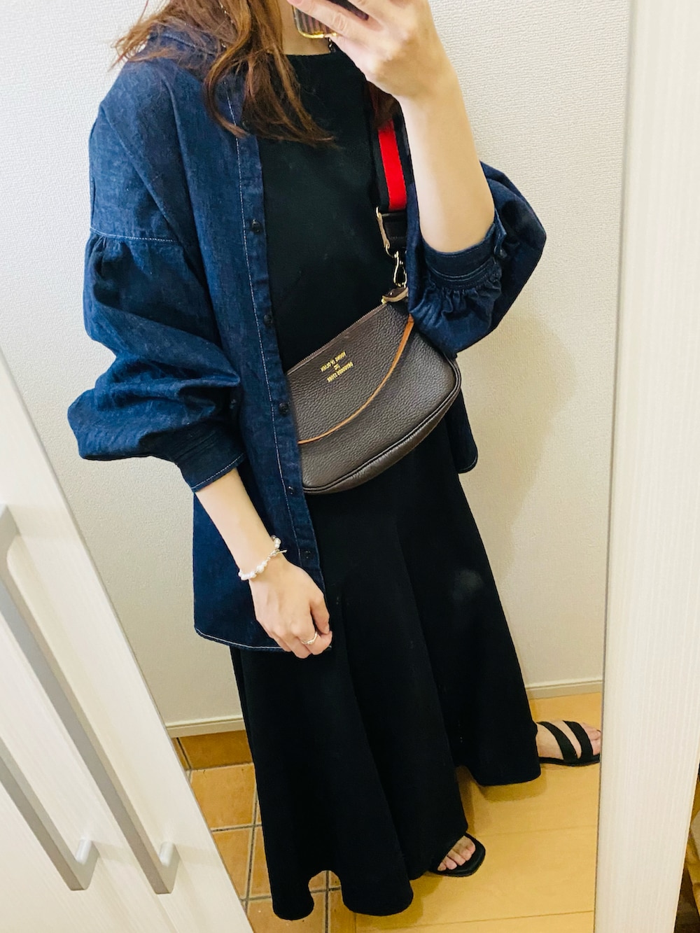 ブラック系のサンダル、ブラック系のワンピース、ブルー系のシャツ/ブラウスを着用したレディースの春コーディネートの2枚目の写真