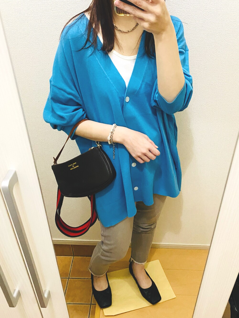 ブルー系のカーディガン/ボレロ、ホワイト系のタンクトップ、その他のバッグを着用したレディースの春コーディネートの2枚目の写真
