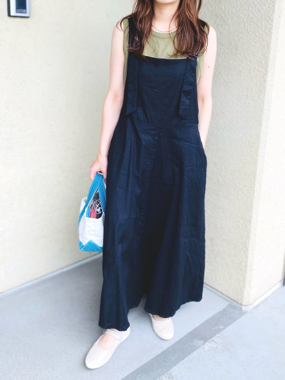 ブラック系のワンピース、グリーン系のTシャツ/カットソー、その他のバッグを着用したレディースの夏コーディネートの2枚目の写真
