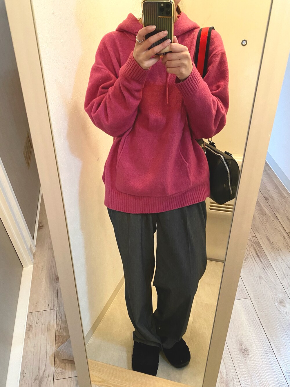 ブラック系のパンツ、ブラック系のショルダーバッグ、ピンク系のニット/セーターを着用したレディースの冬コーディネートの3枚目の写真