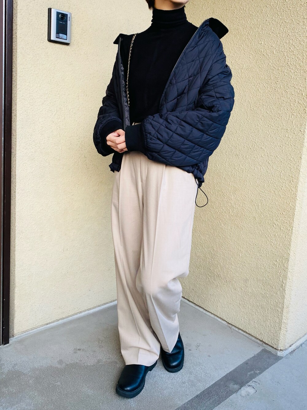 ブラック系のニット/セーター、ベージュ系のパンツ、ブラック系のブルゾンを着用したレディースの冬コーディネートの4枚目の写真