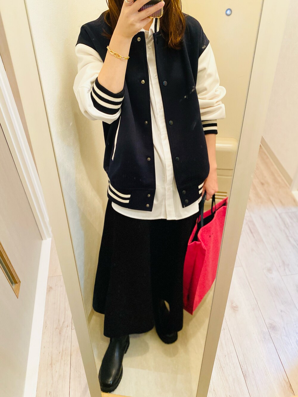 ブルー系のスタジャン、ブラック系のスカート、ブラック系のブーツを着用したレディースの秋コーディネートの2枚目の写真