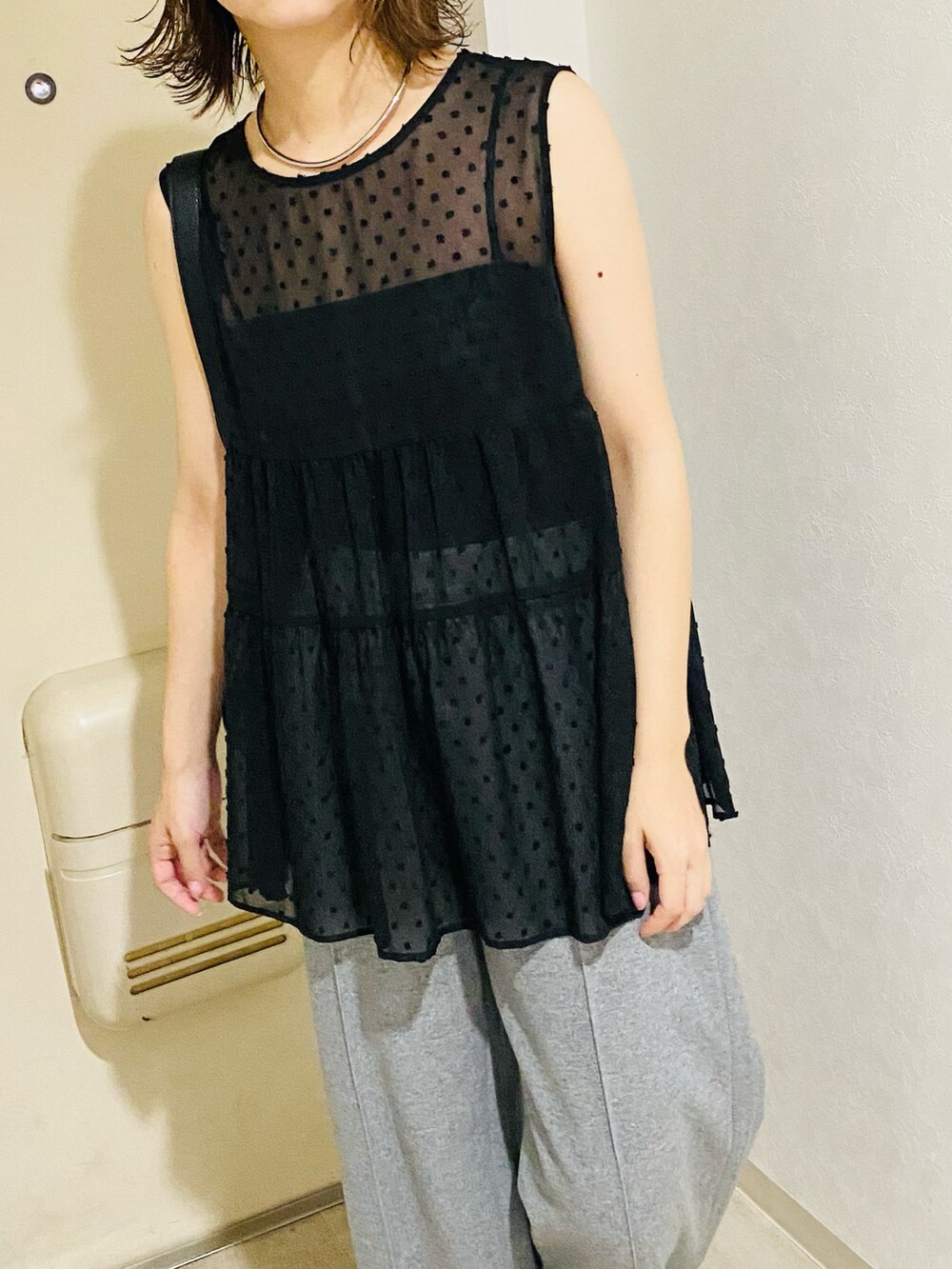 ブラック系のシャツ/ブラウス、グレー系のパンツを着用したレディースの秋コーディネートの4枚目の写真