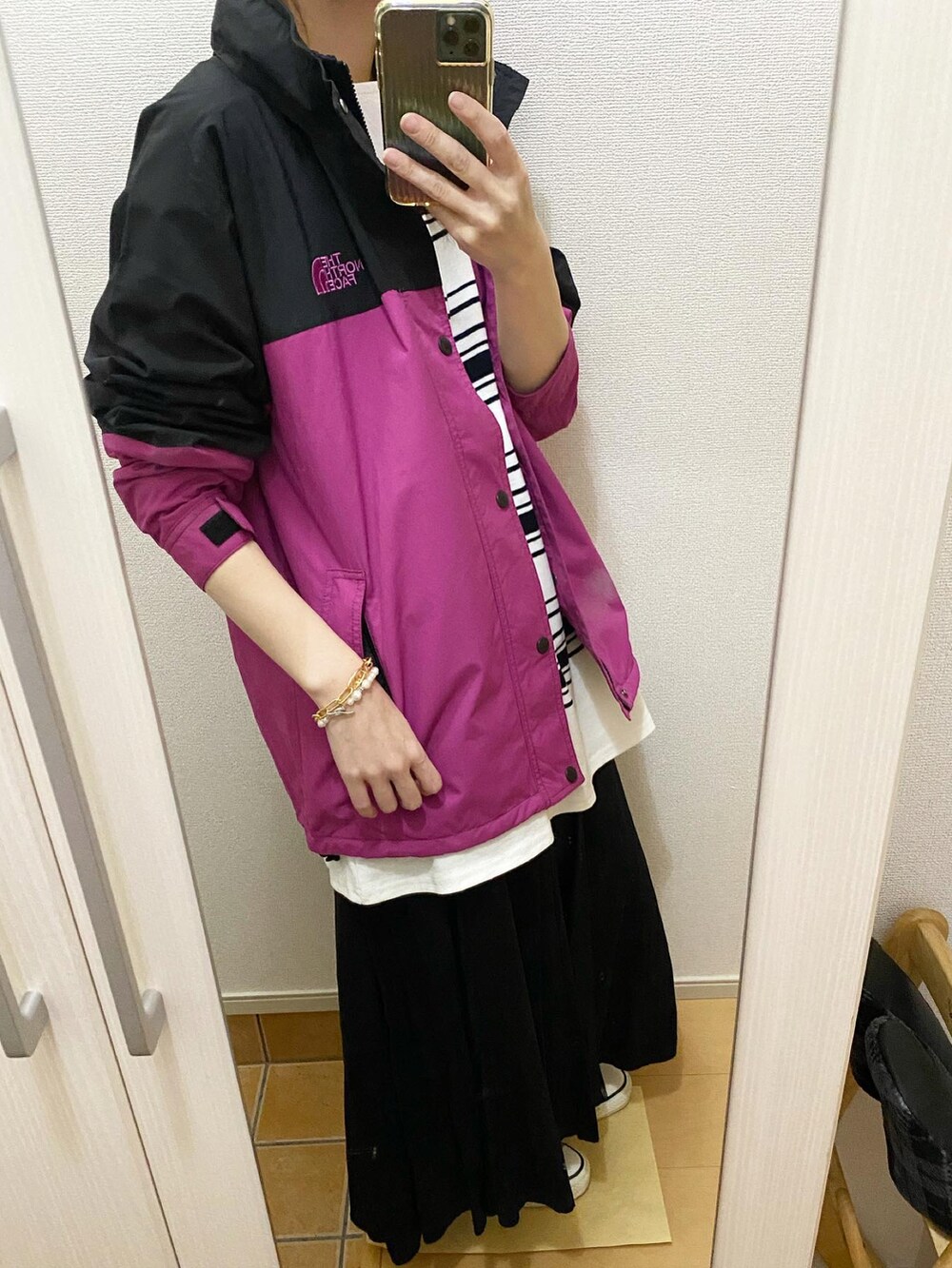 パープル系のブルゾン、ブラック系のTシャツ/カットソー、ブラック系のスカートを着用したレディースの春コーディネートの2枚目の写真