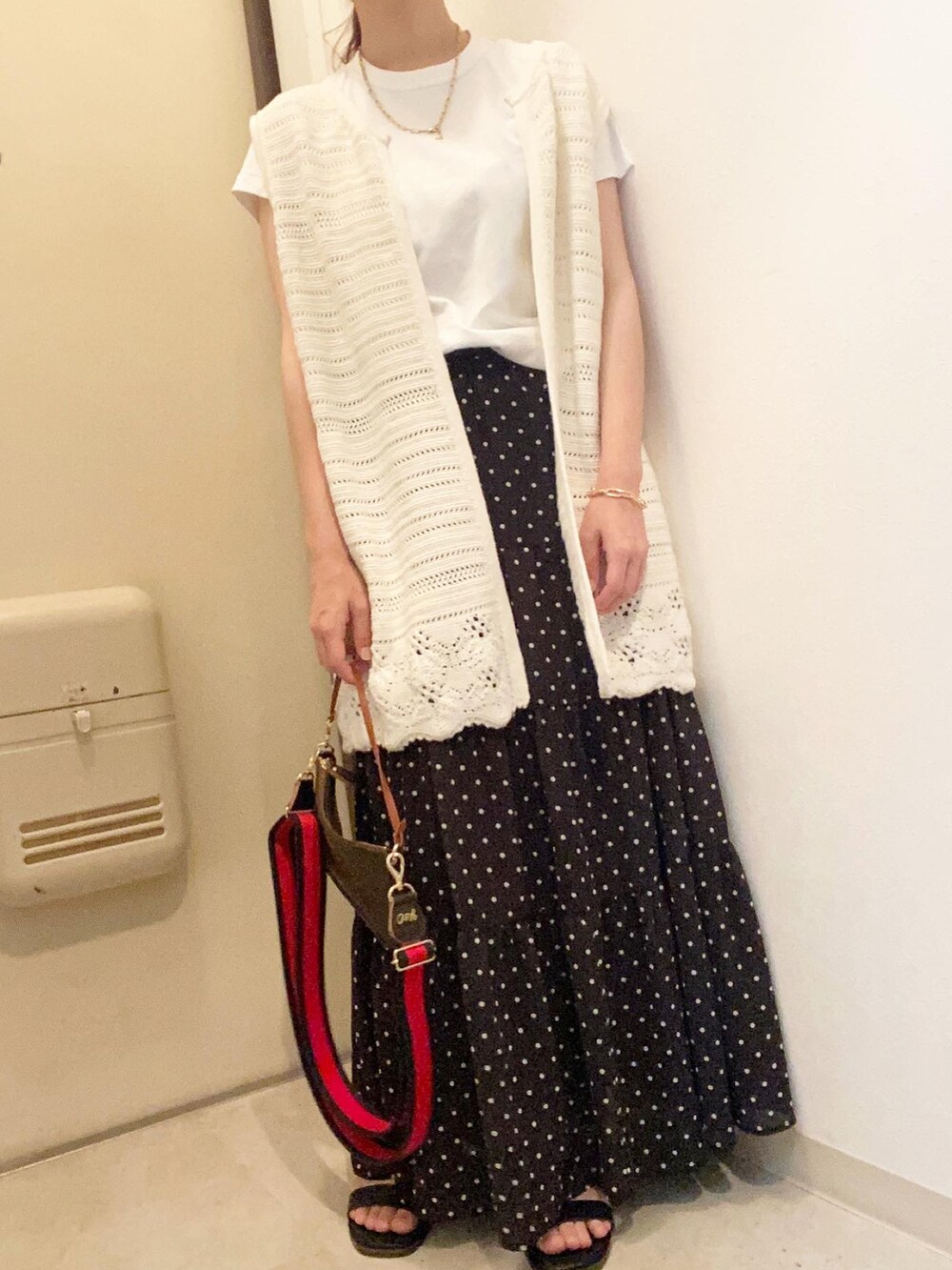 ブラック系のスカート、ホワイト系のベスト、ホワイト系のTシャツ/カットソーを着用したレディースの夏コーディネートの2枚目の写真