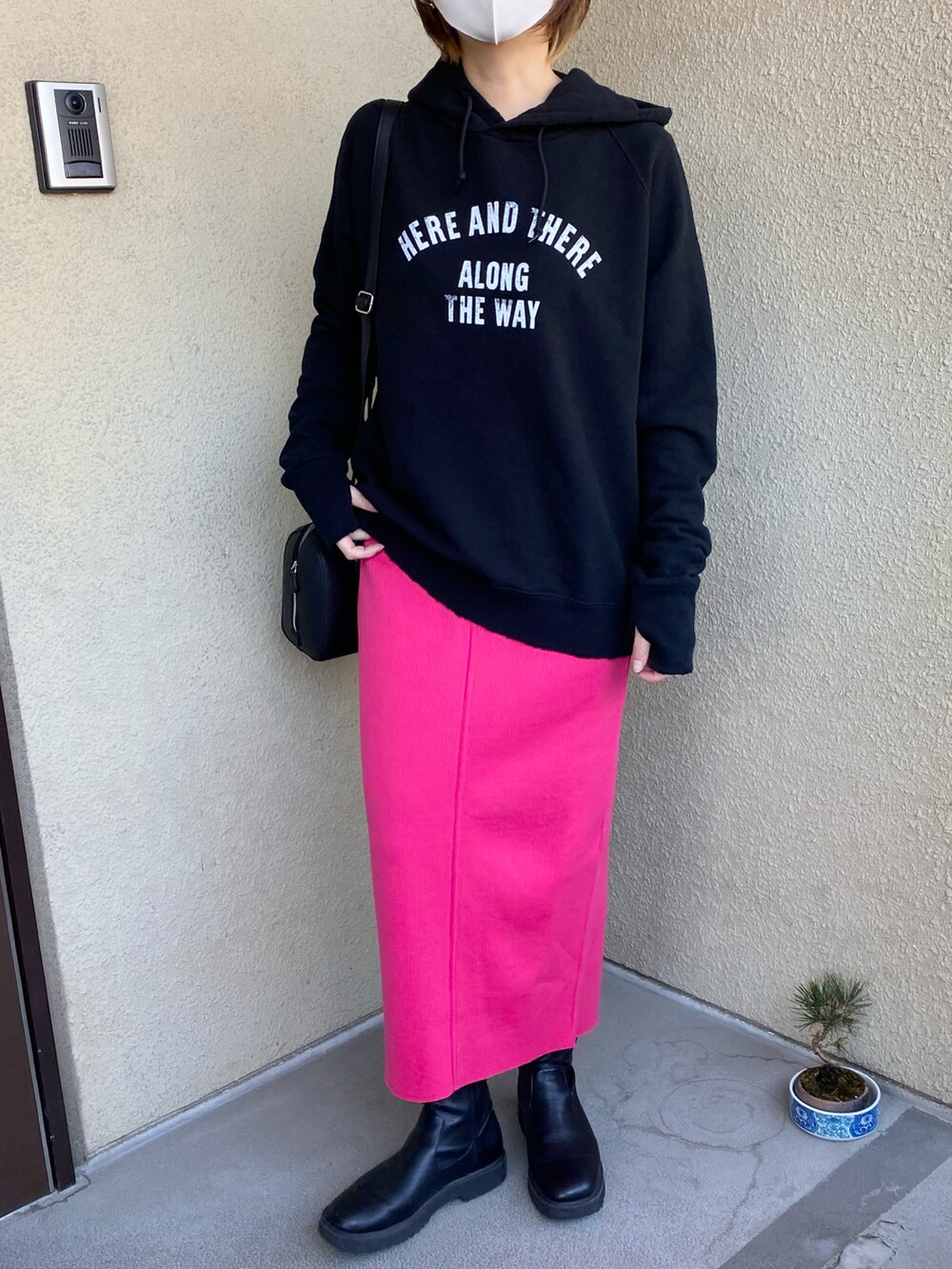 ブラック系のパーカー、ピンク系のスカートを着用したレディースの春コーディネートの2枚目の写真