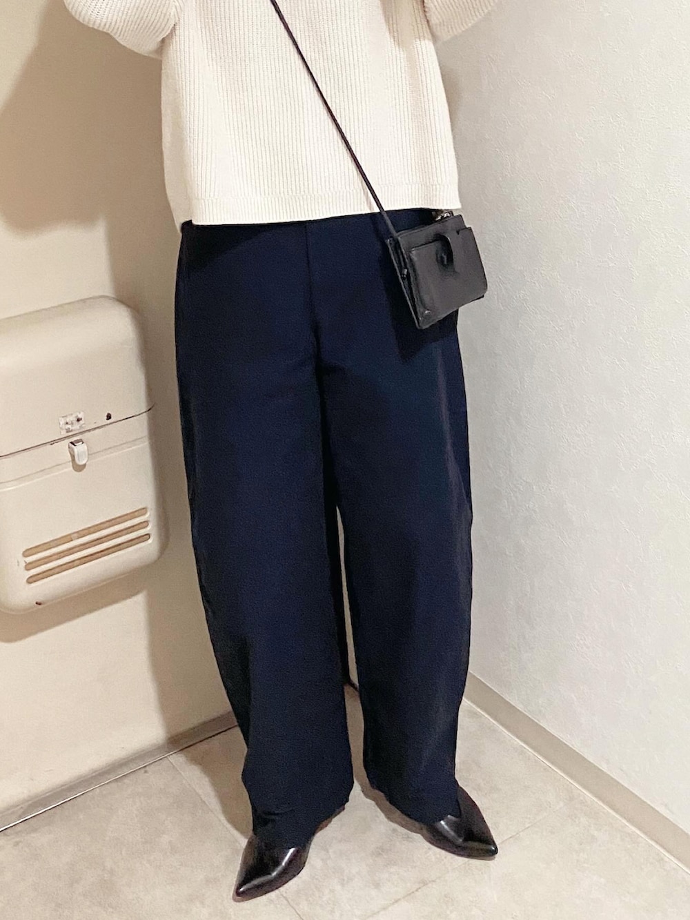 ブルー系のカーゴパンツ、ブラック系のパンプス、ホワイト系のニット/セーターを着用したレディースの冬コーディネートの3枚目の写真