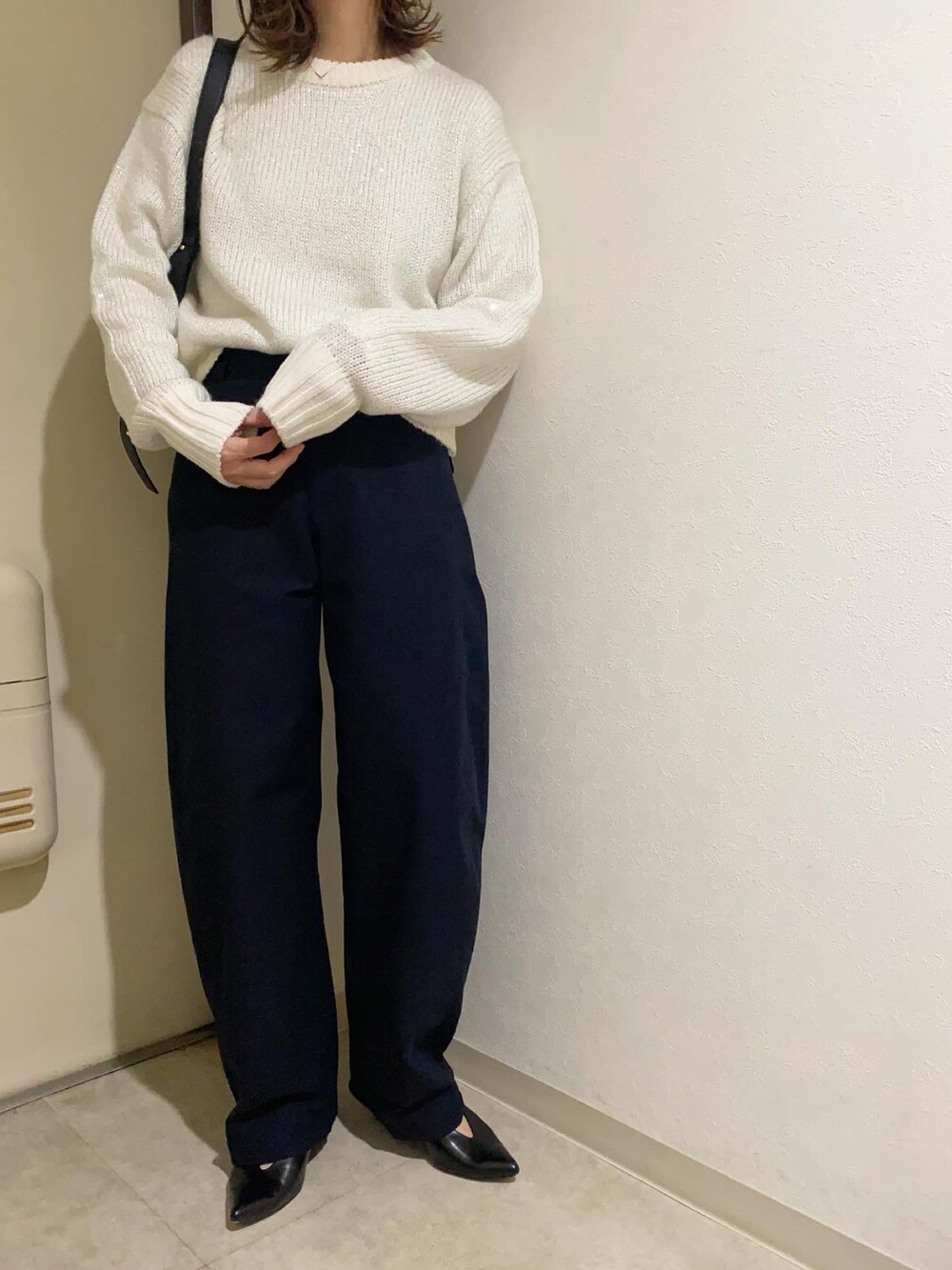 ホワイト系のニット/セーター、ブルー系のカーゴパンツ、ホワイト系のTシャツ/カットソーを着用したレディースの冬コーディネートの2枚目の写真