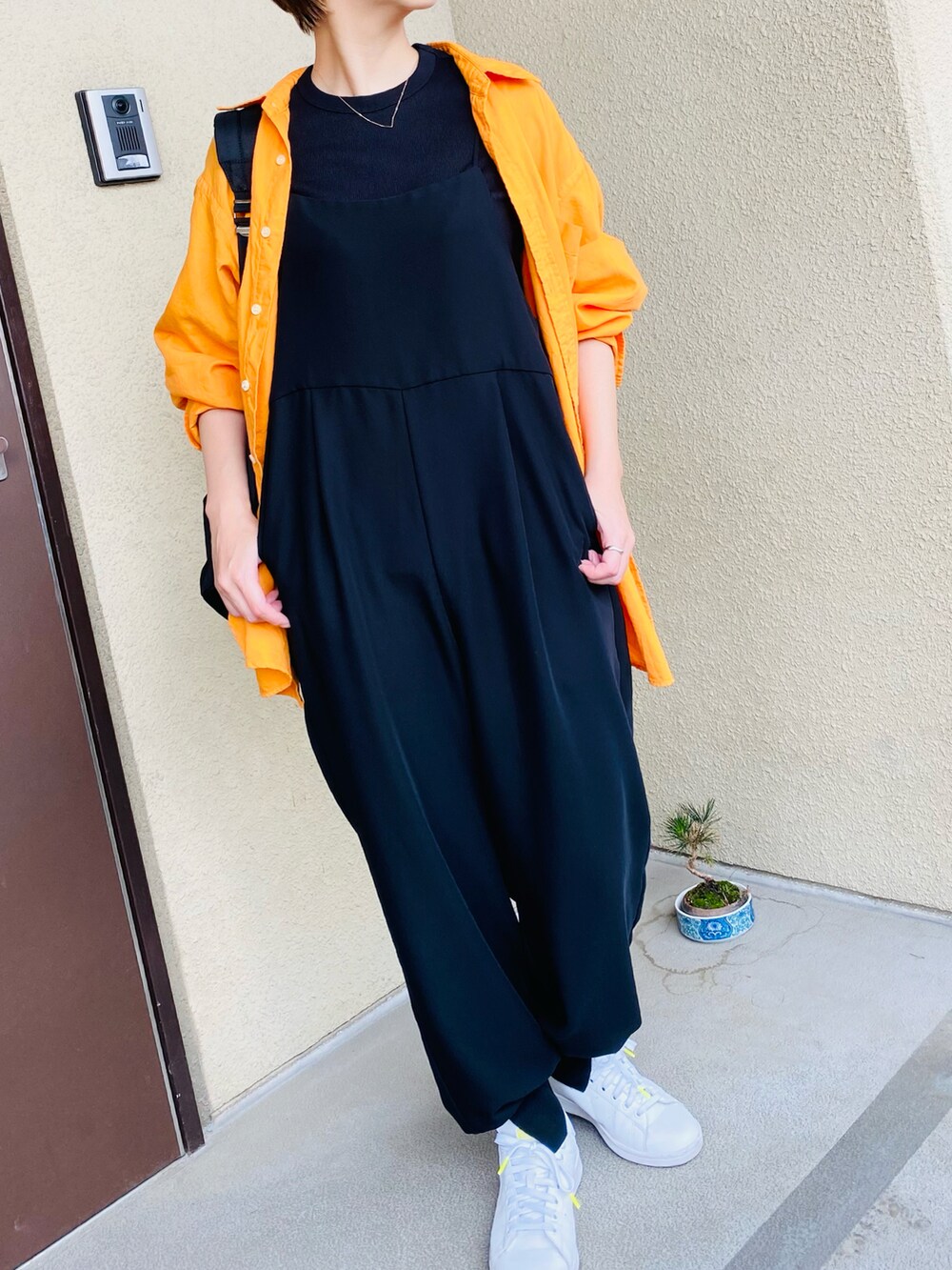 ブラック系のサロペット/オーバーオール、オレンジ系のシャツ/ブラウス、ブラック系のTシャツ/カットソーを着用したレディースの春コーディネートの3枚目の写真