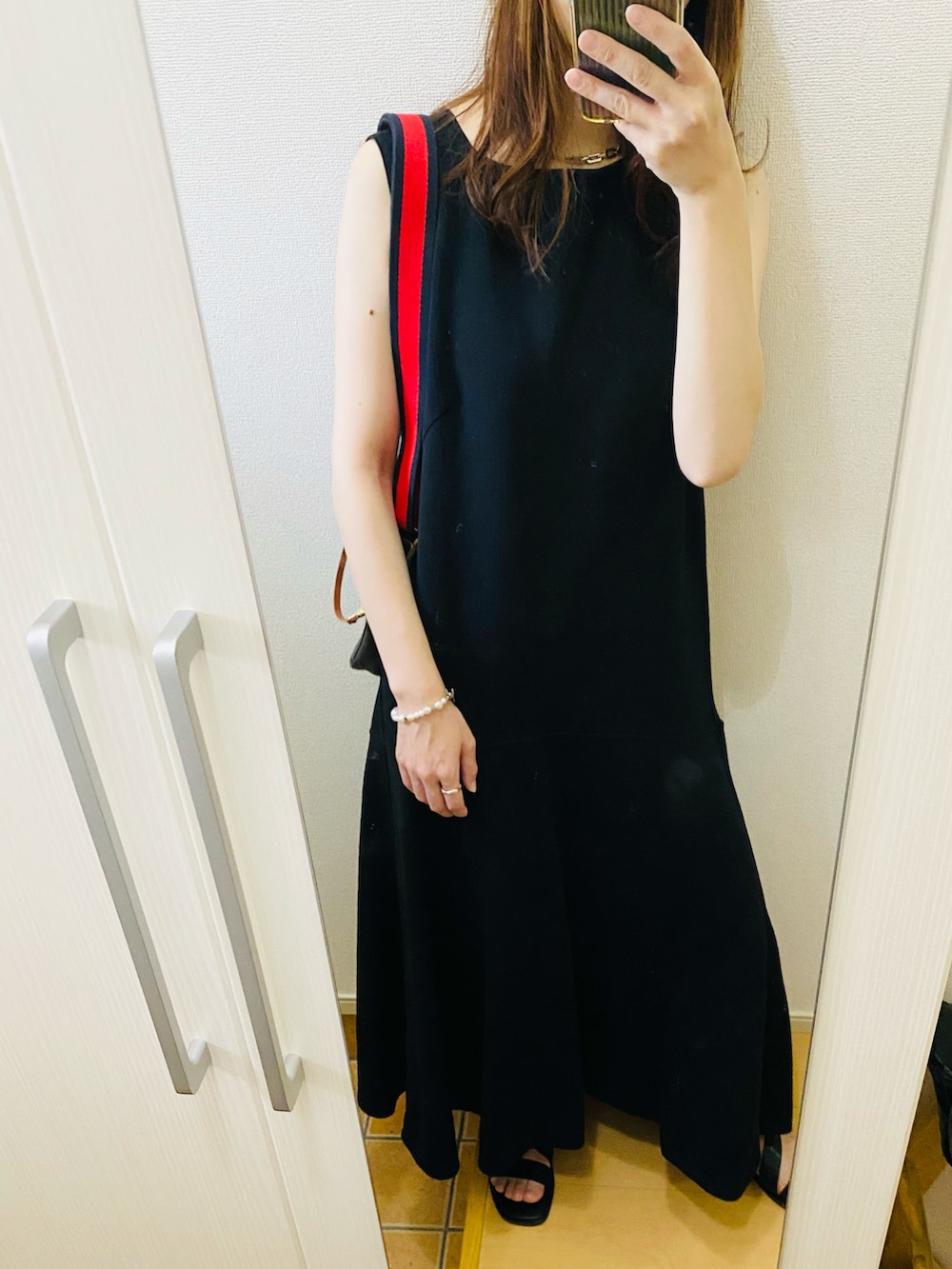 ブラック系のサンダル、ブラック系のワンピース、ブルー系のシャツ/ブラウスを着用したレディースの春コーディネートの3枚目の写真