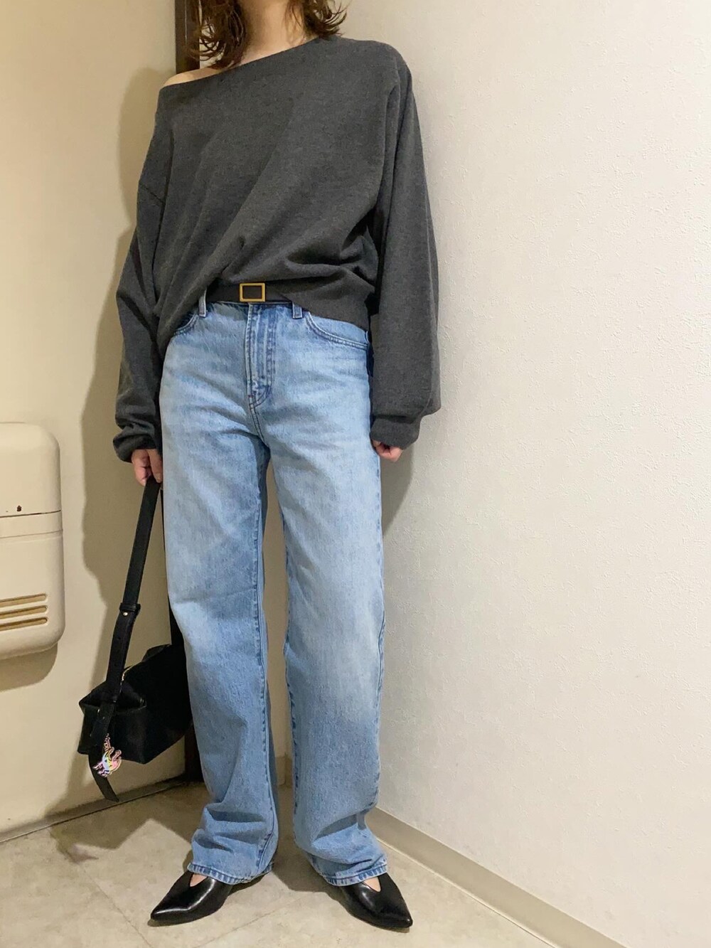 ブルー系のデニムパンツ、グレー系のニット/セーター、ブラック系のベルトを着用したレディースの冬コーディネートの3枚目の写真