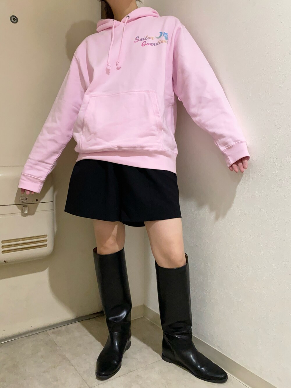 ブラック系のその他パンツ、ブラック系のブーツ、ピンク系のパーカーを着用したレディースの冬コーディネートの5枚目の写真