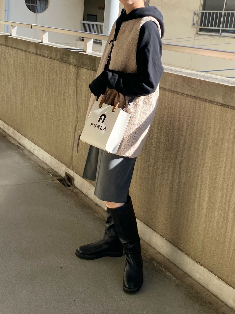 ベージュ系のその他アウター、ブラック系のパーカー、グレー系のスラックスを着用したレディースの秋コーディネートの2枚目の写真