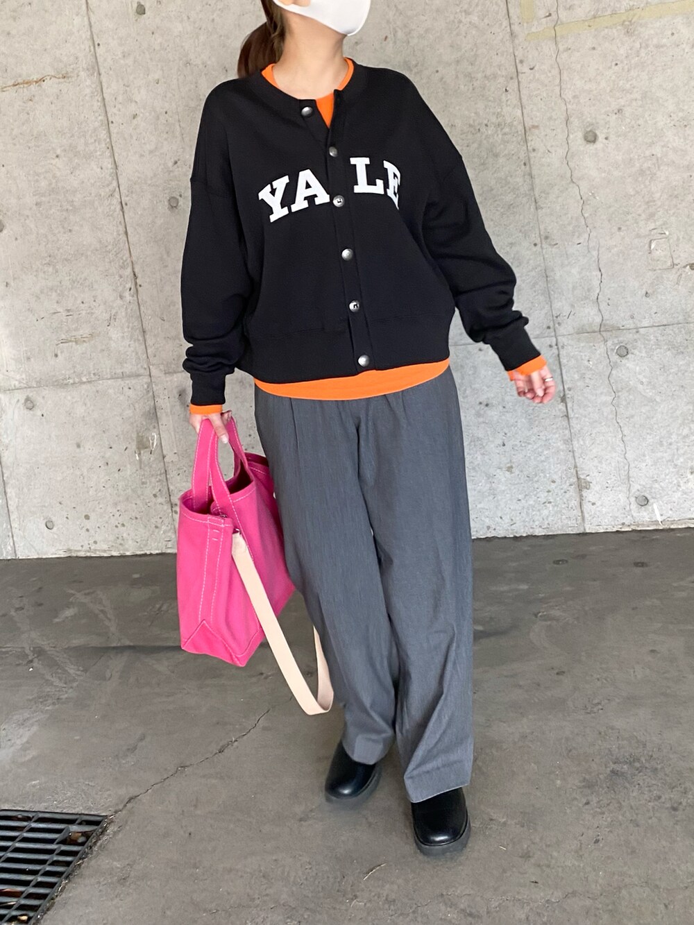 グレー系のカーディガン/ボレロ、ブラック系のパンツ、オレンジ系のTシャツ/カットソーを着用したレディースの冬コーディネートの2枚目の写真