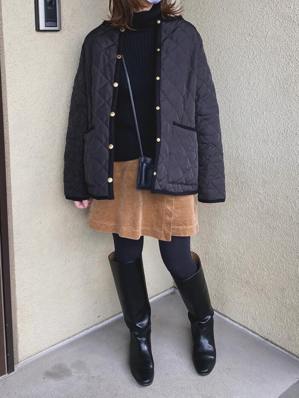 ブラック系のニット/セーター、ブラウン系のスカート、ブラック系のブーツを着用したレディースの冬コーディネートの3枚目の写真