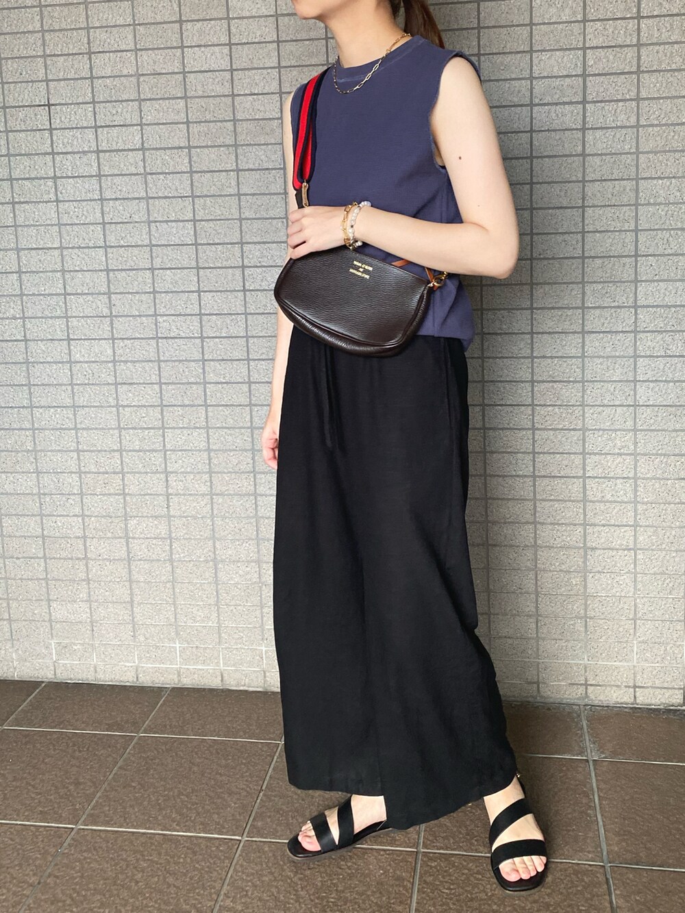 ブルー系のTシャツ/カットソー、ブラック系のパンツ、ブラック系のサンダルを着用したレディースの夏コーディネートの2枚目の写真