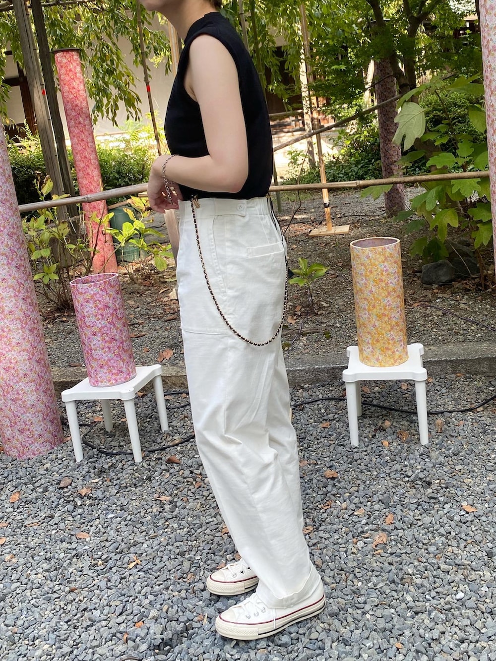 グレー系のトップス、ホワイト系のカーゴパンツ、ブラック系のサスペンダーを着用したレディースの夏コーディネートの3枚目の写真