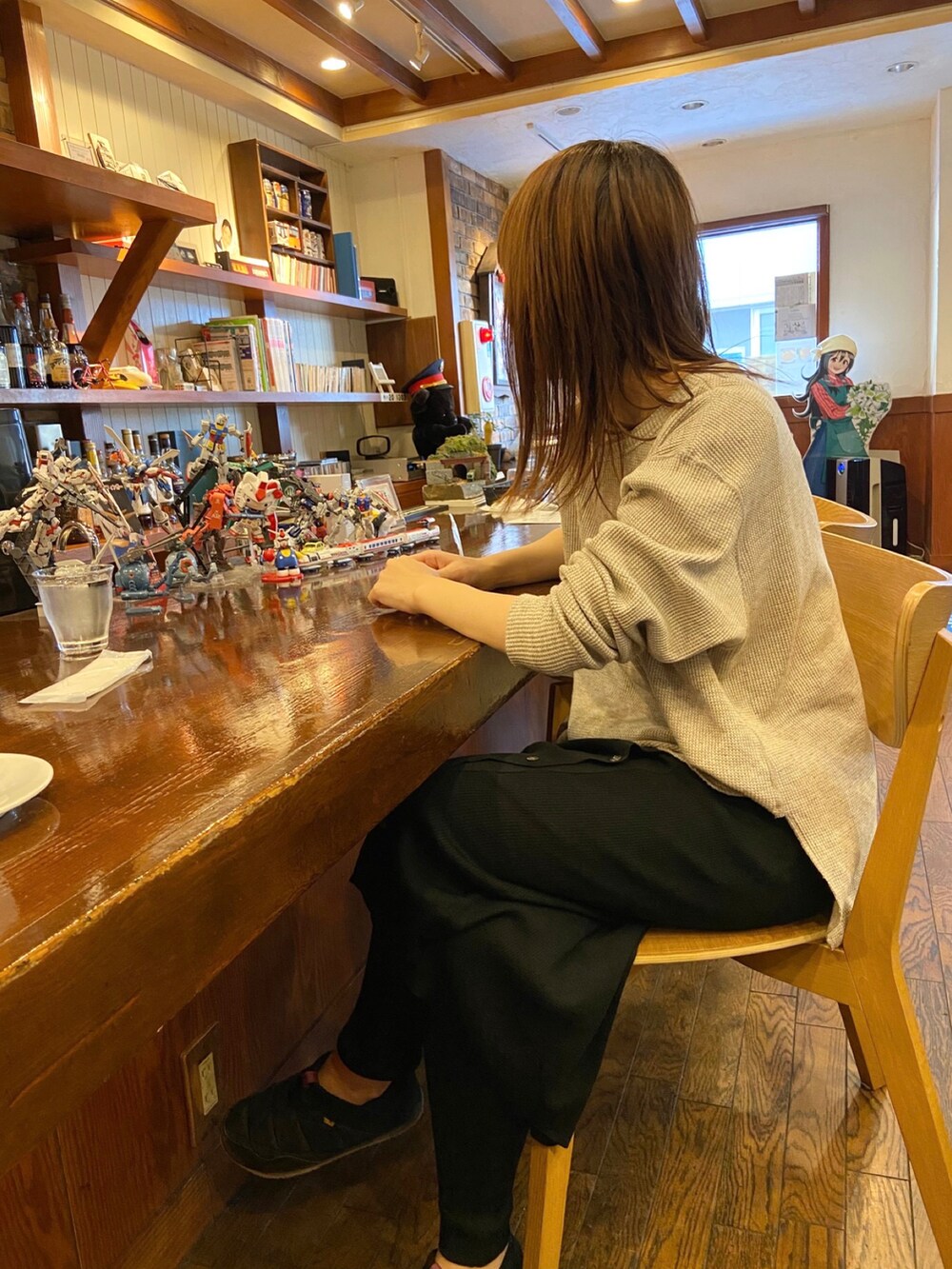 ベージュ系のTシャツ/カットソー、ブラック系のスカート、ベージュ系のトートバッグを着用したレディースの秋コーディネートの2枚目の写真