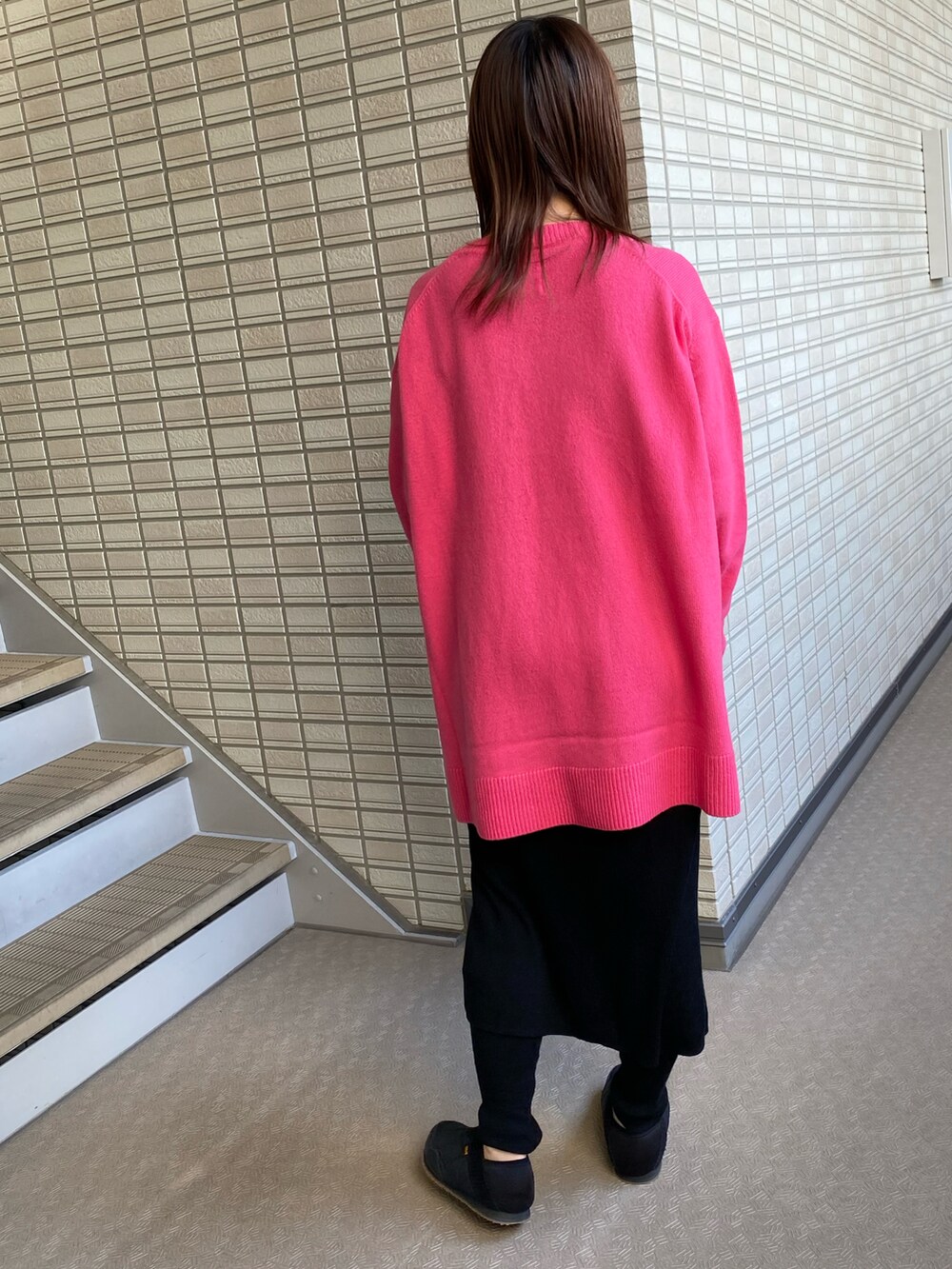 ピンク系のニット/セーター、ブラック系のスカート、ベージュ系のその他アウターを着用したレディースの秋コーディネートの3枚目の写真