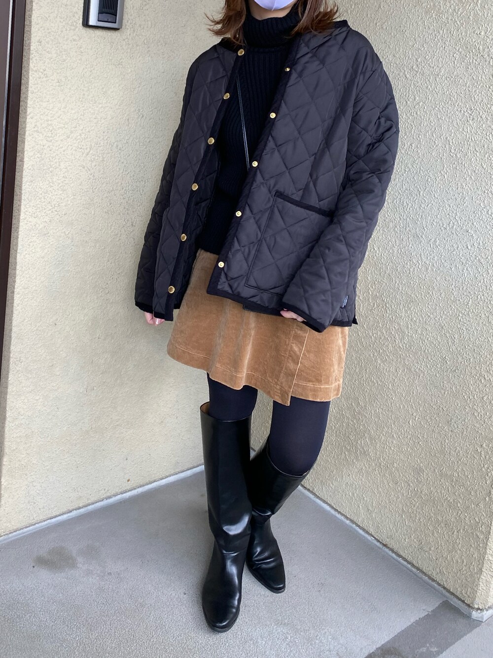 ブラック系のニット/セーター、ブラウン系のスカート、ブラック系のブーツを着用したレディースの冬コーディネートの2枚目の写真