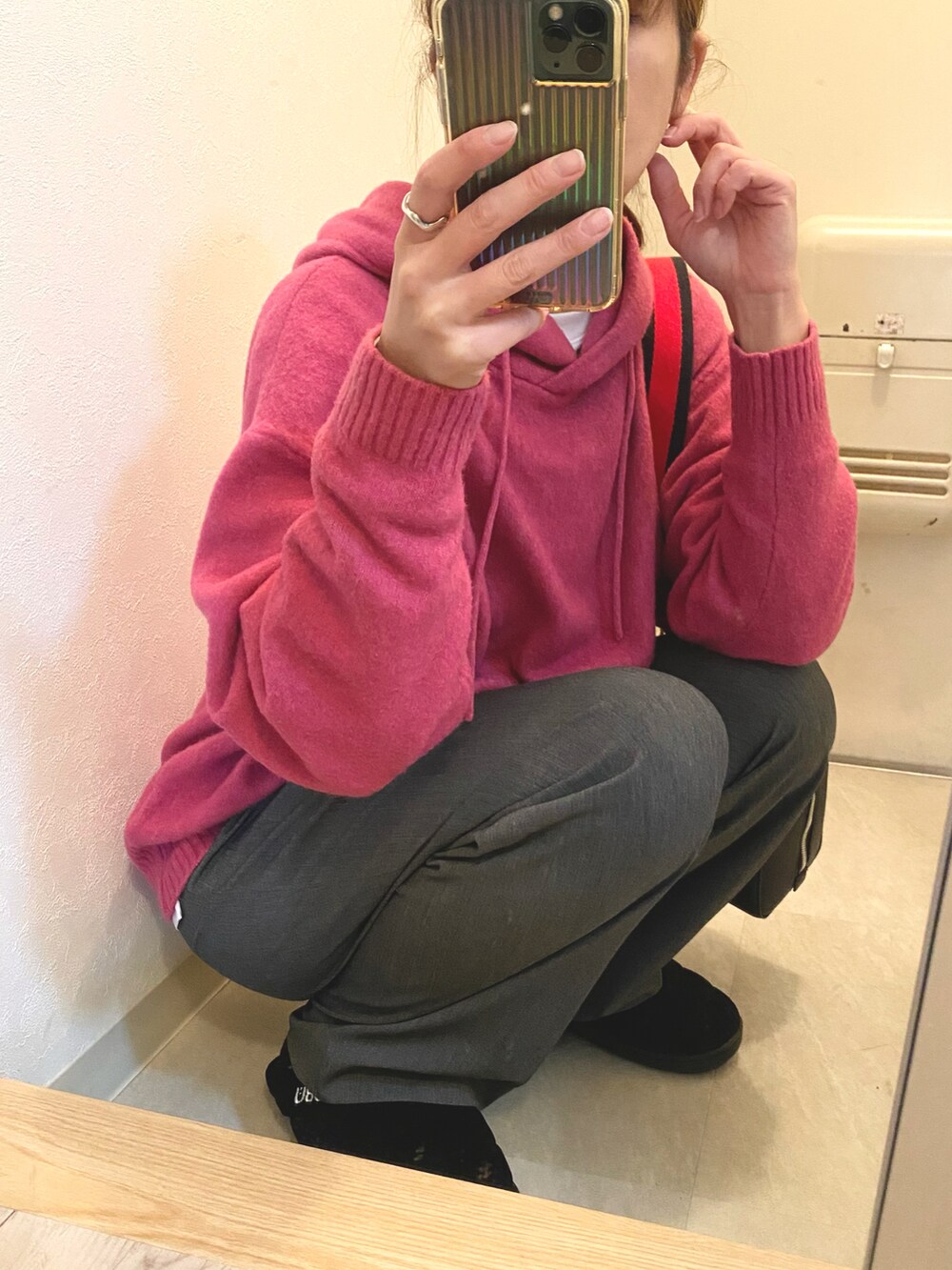 ブラック系のパンツ、ブラック系のショルダーバッグ、ピンク系のニット/セーターを着用したレディースの冬コーディネートの4枚目の写真