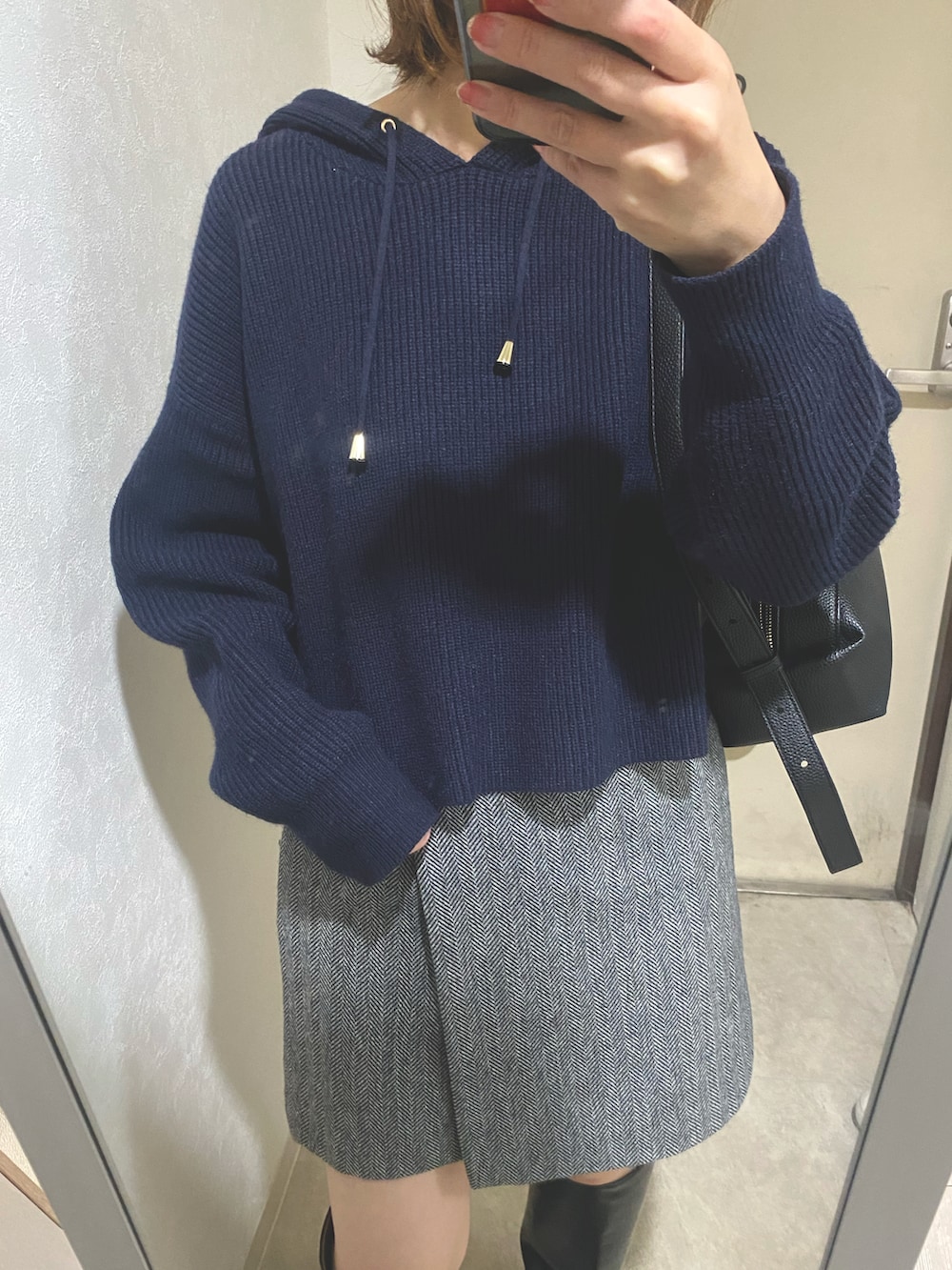 ブラック系のトートバッグ、ブルー系のパーカー、ブラック系のブーツを着用したレディースの秋コーディネートの4枚目の写真