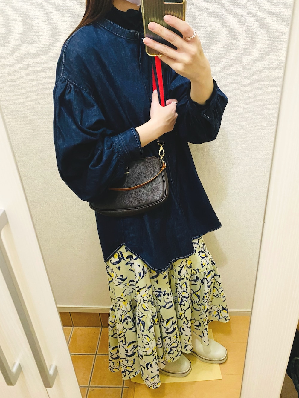 ブルー系のシャツ/ブラウス、ブラック系のTシャツ/カットソー、ベージュ系のステンカラーコートを着用したレディースの春コーディネートの2枚目の写真