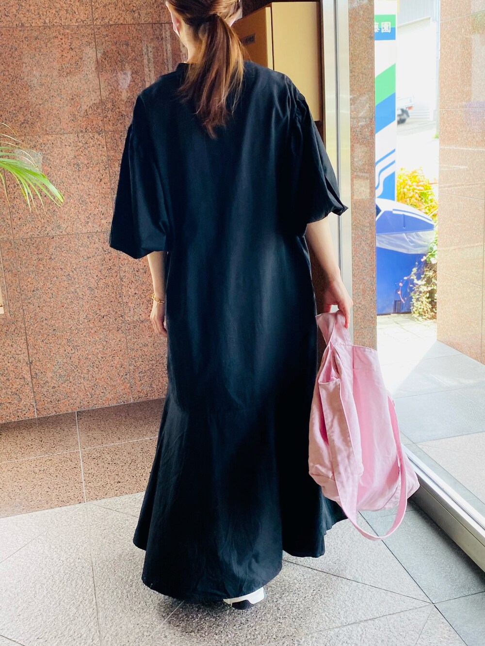 ブラック系のワンピース、ピンク系のトートバッグ、ホワイト系のタンクトップを着用したレディースの夏コーディネートの3枚目の写真