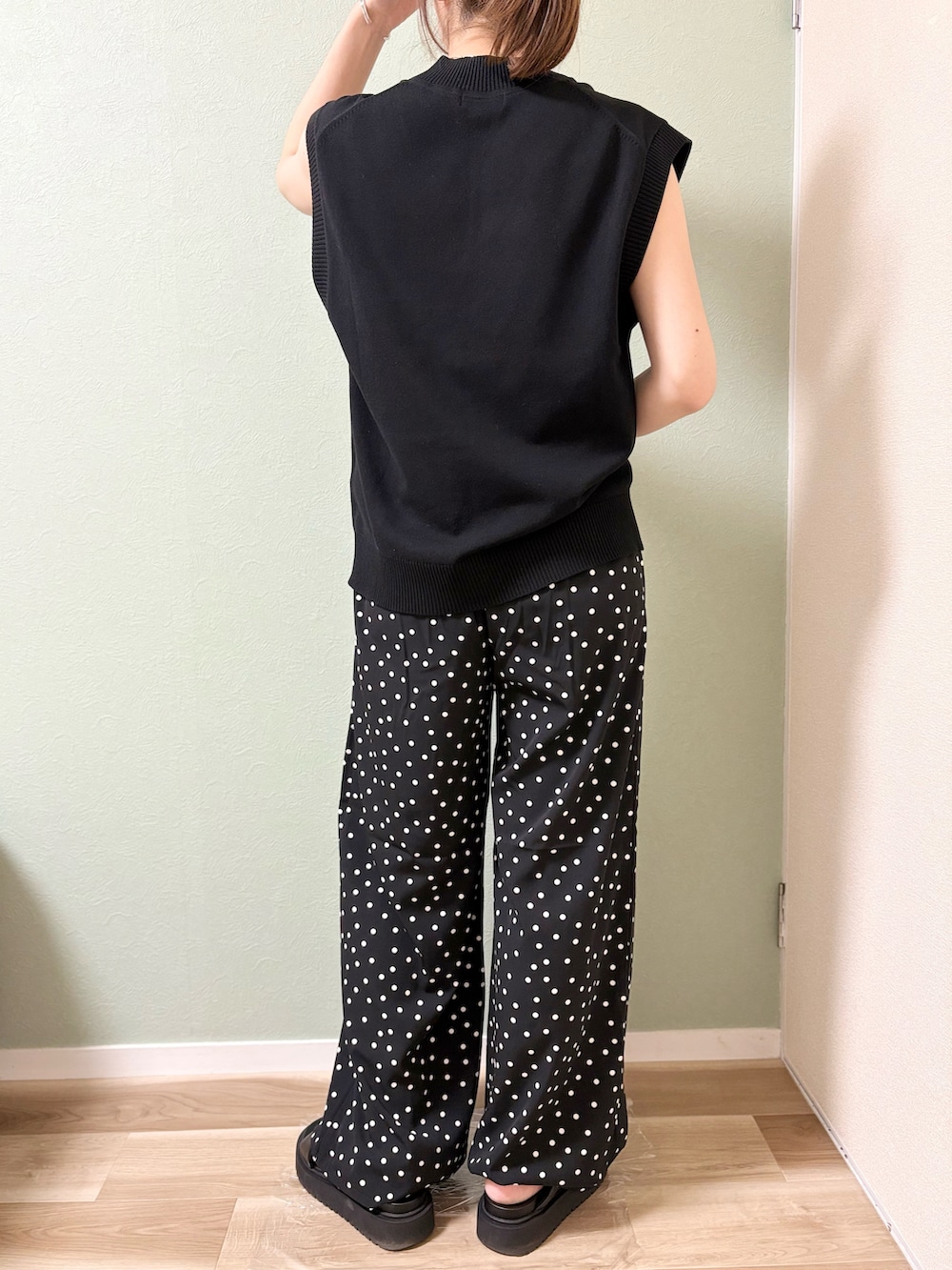 ブラック系のパンツ、ブラック系のベスト、ブラック系のサンダルを着用したレディースの夏コーディネートの4枚目の写真