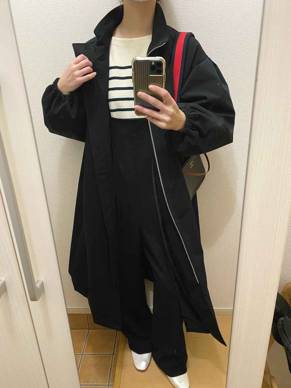 ホワイト系のパンプス、ブラウン系のショルダーバッグ、ブラック系のサロペット/オーバーオールを着用したレディースの冬コーディネートの2枚目の写真
