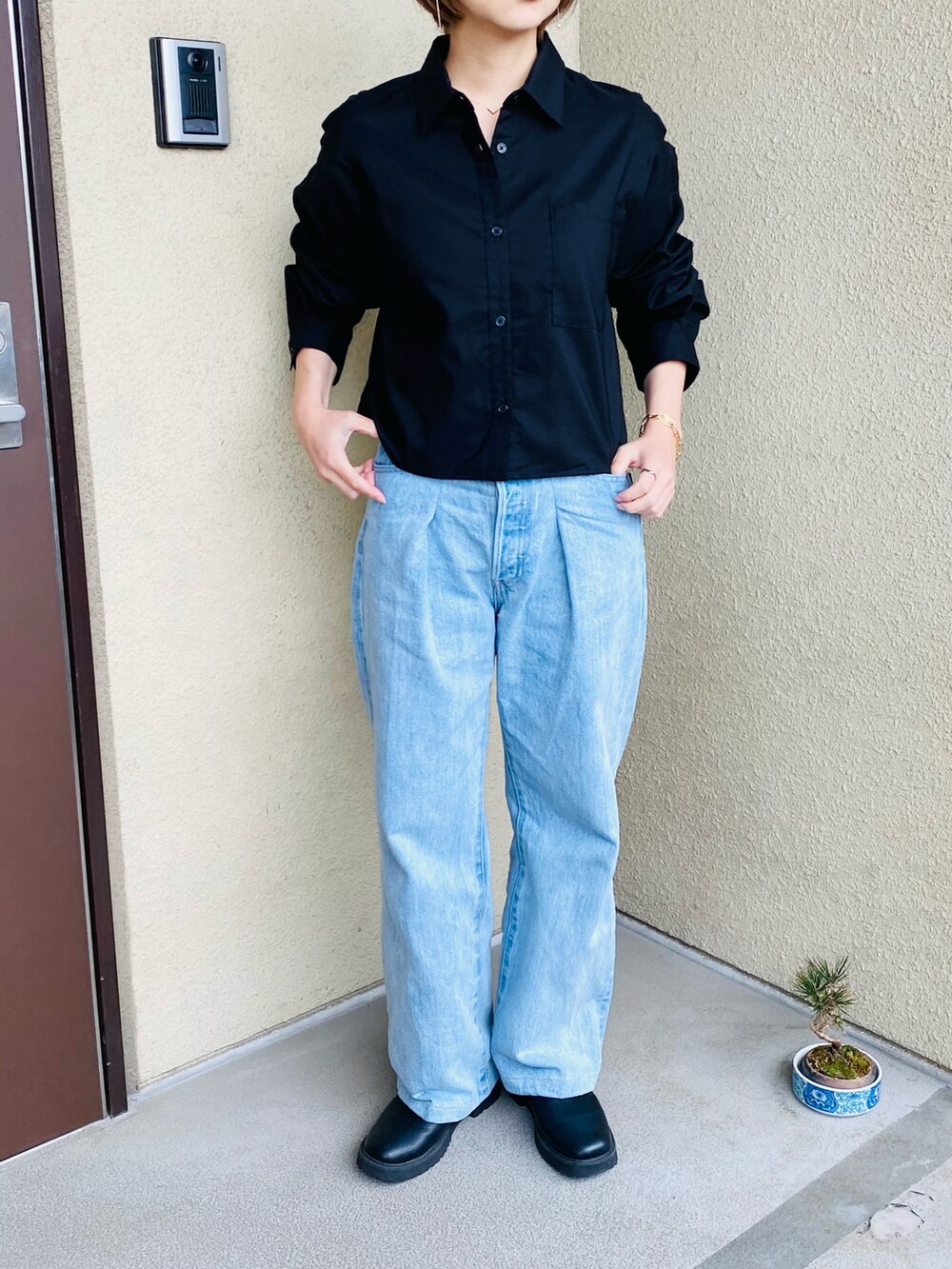 ブルー系のデニムパンツ、ベージュ系のステンカラーコート、ブラック系のシャツ/ブラウスを着用したレディースの春コーディネートの2枚目の写真