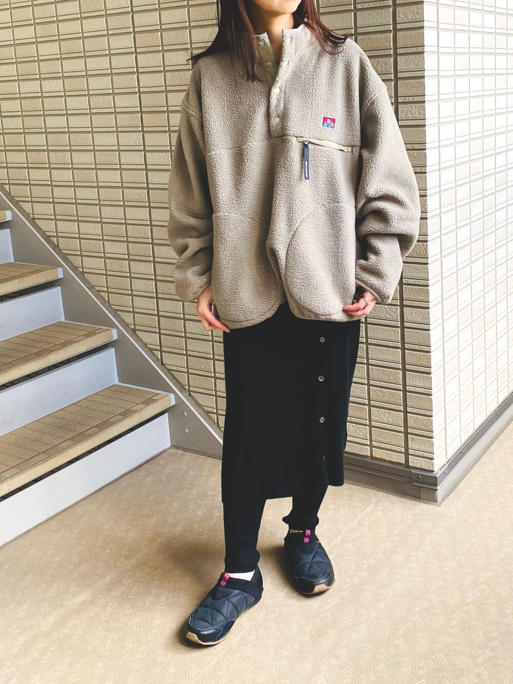 ブラック系のスカート、ブラック系のスニーカー、ベージュ系のその他アウターを着用したレディースの冬コーディネートの3枚目の写真