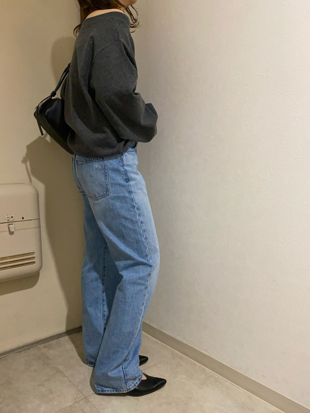 ブルー系のデニムパンツ、グレー系のニット/セーター、ブラック系のベルトを着用したレディースの冬コーディネートの4枚目の写真