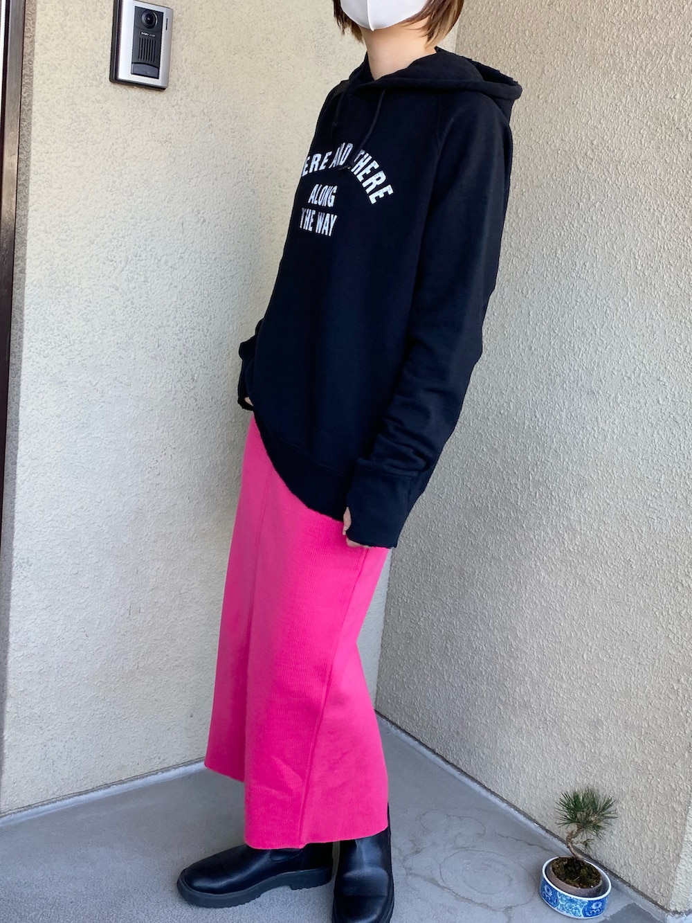 ブラック系のパーカー、ピンク系のスカートを着用したレディースの春コーディネートの3枚目の写真