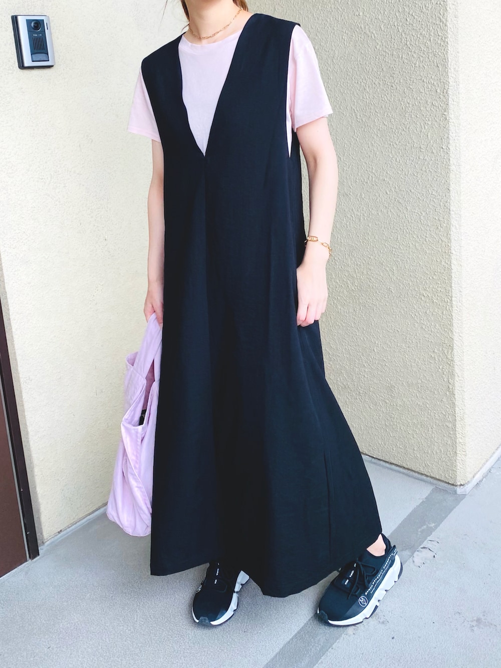 ブラック系のジャンパースカート、ピンク系のトートバッグ、ブラック系のスニーカーを着用したレディースの夏コーディネートの3枚目の写真