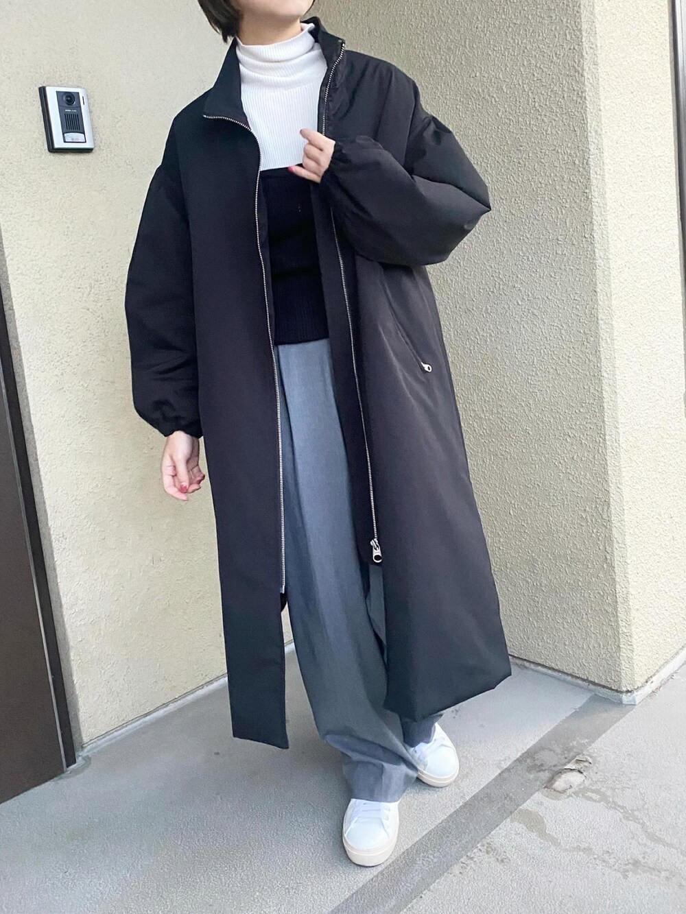 ホワイト系のニット/セーター、ブラック系のその他トップス、ベージュ系のパンツを着用したレディースの冬コーディネートの4枚目の写真