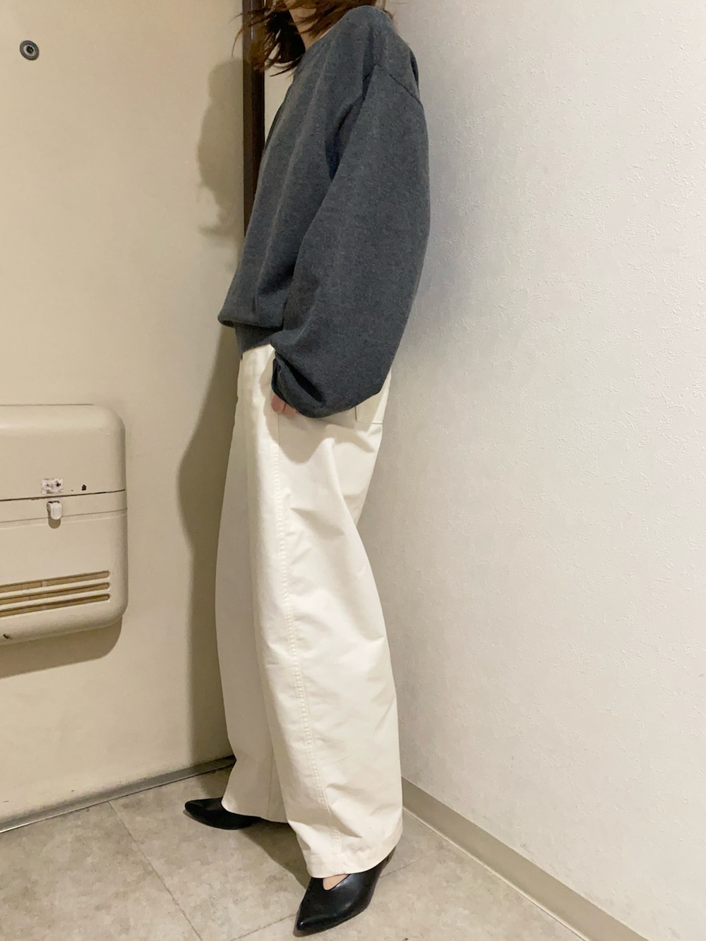 グレー系のニット/セーター、ホワイト系のパンツ、ブルー系のトートバッグを着用したレディースの冬コーディネートの4枚目の写真