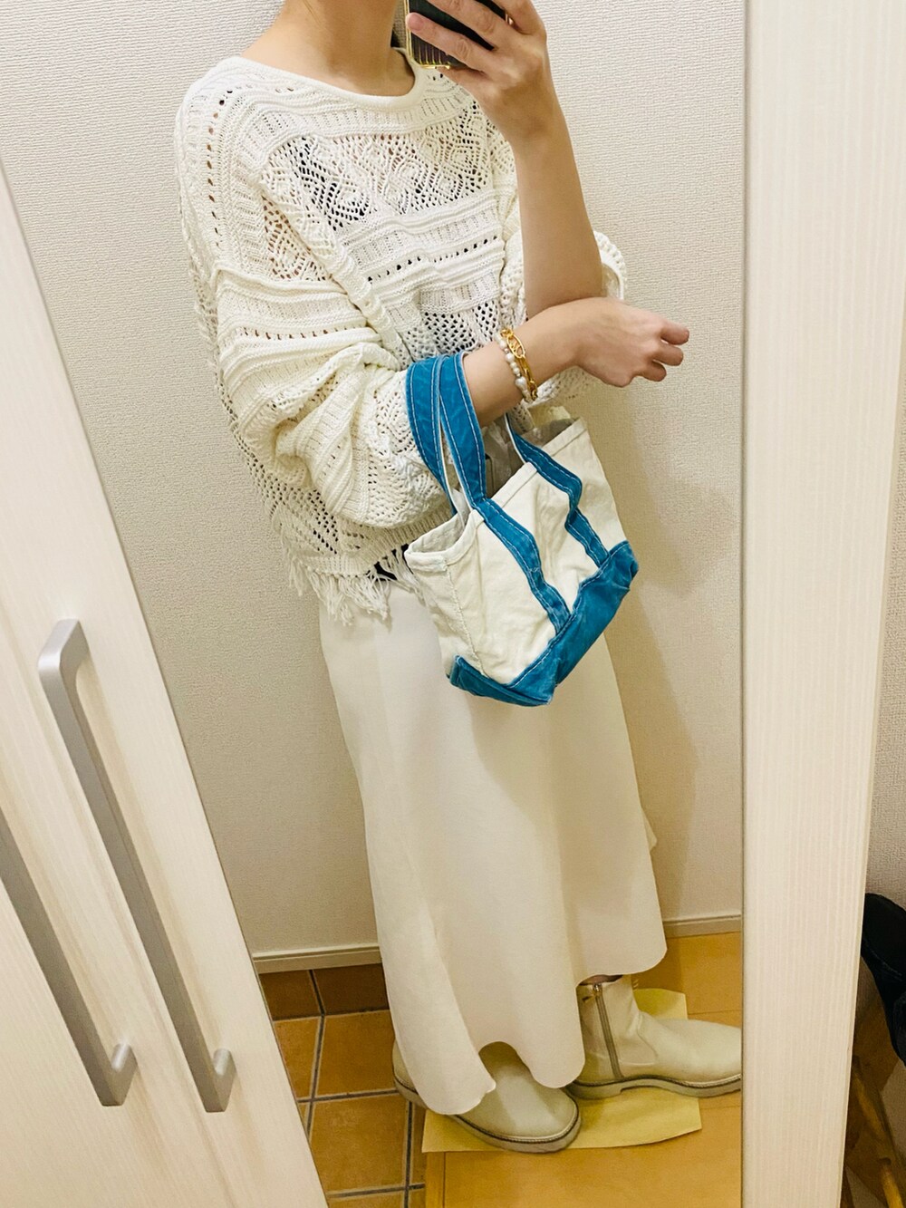 ホワイト系のスカート、ホワイト系のニット/セーター、その他のバッグを着用したレディースの春コーディネートの2枚目の写真