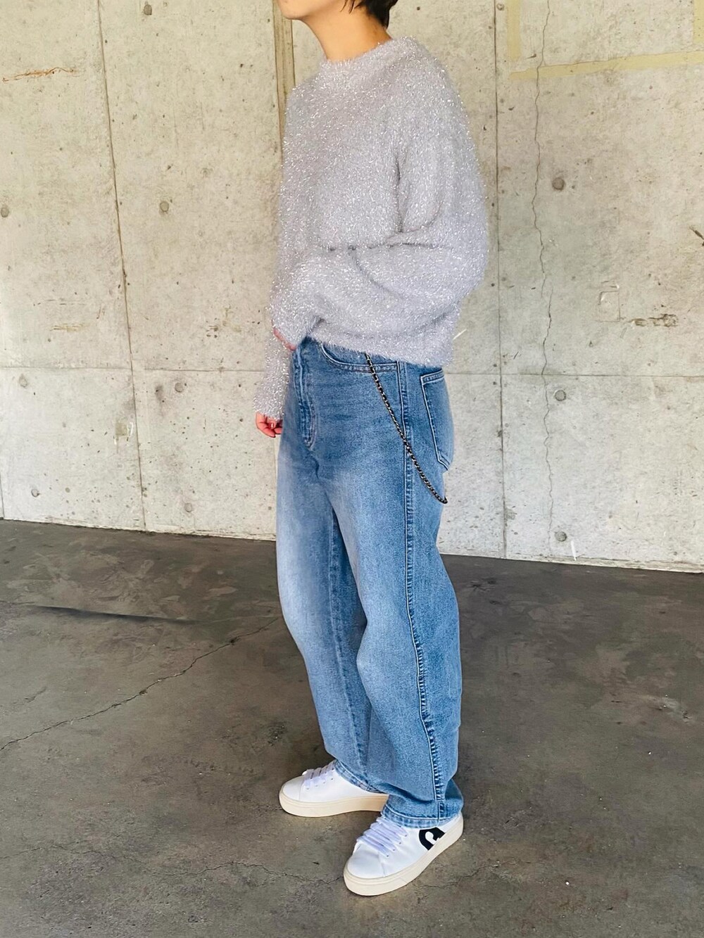 ホワイト系のスニーカー、ブルー系のデニムパンツ、グレー系のニット/セーターを着用したレディースの冬コーディネートの3枚目の写真