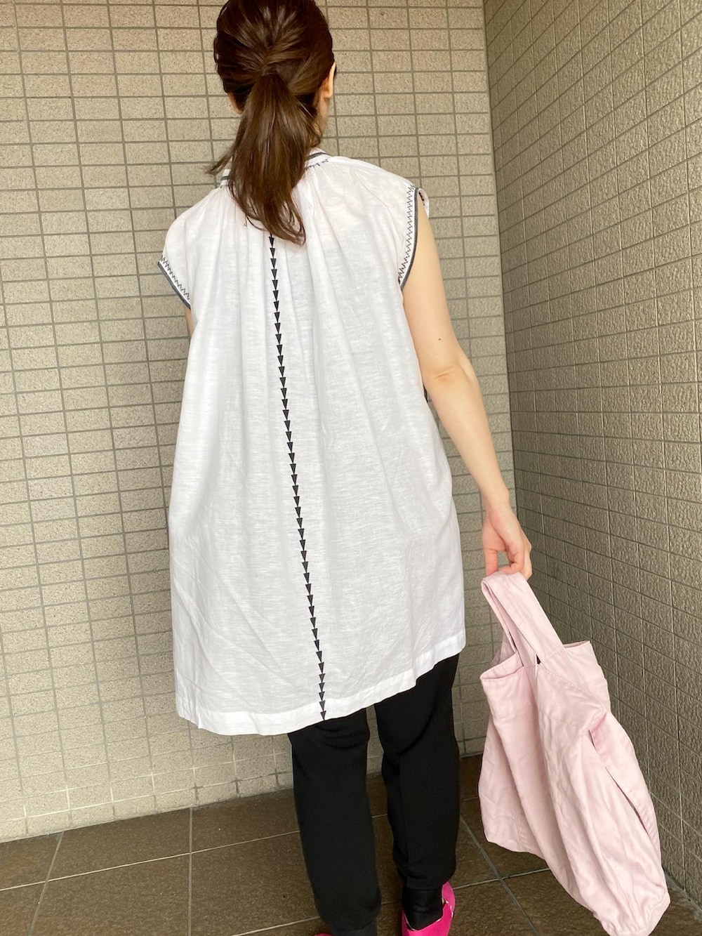 ピンク系のトートバッグ、ホワイト系のシャツ/ブラウス、ブラック系のその他パンツを着用したレディースの夏コーディネートの2枚目の写真