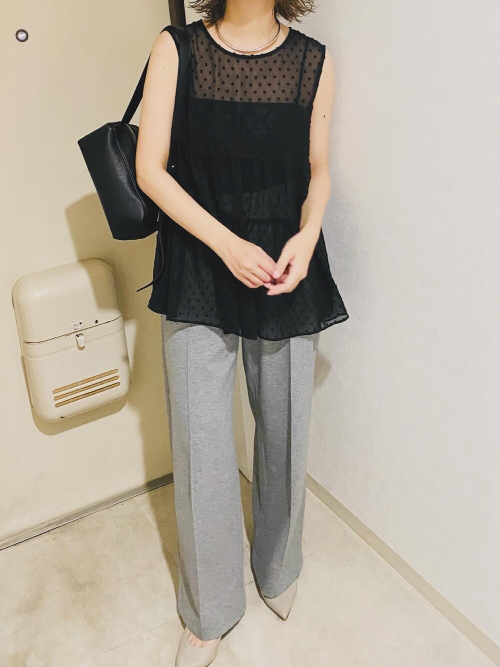 ブラック系のシャツ/ブラウス、グレー系のパンツを着用したレディースの秋コーディネートの3枚目の写真