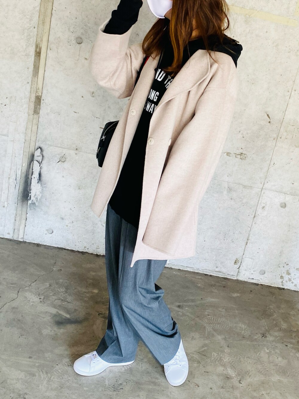 ブラック系のパンツ、ベージュ系のその他アウター、ブラック系のパーカーを着用したレディースの冬コーディネートの2枚目の写真