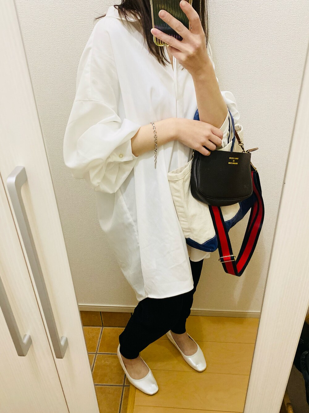 ブラック系のその他パンツ、ブルー系のトートバッグ、ブラウン系のショルダーバッグを着用したレディースの冬コーディネートの4枚目の写真