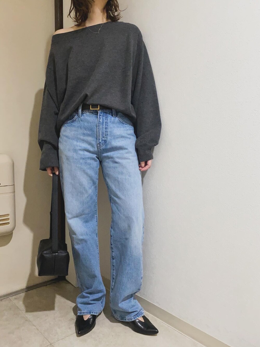 ブルー系のデニムパンツ、グレー系のニット/セーター、ブラック系のベルトを着用したレディースの冬コーディネートの2枚目の写真