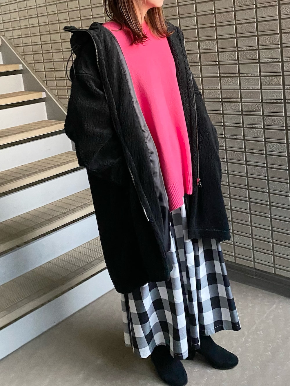 ピンク系のニット/セーター、ブラック系のその他アウター、ブラック系のスカートを着用したレディースの秋コーディネートの2枚目の写真